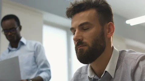 Young serious office worker analysing information on his laptop Stock Footage 68302216