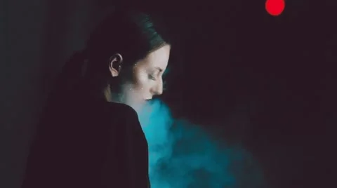 Young sexy brunette over black background with smoke Stock Footage