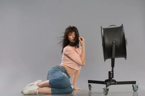 Young sexy female model posing with working fan Stock Photos