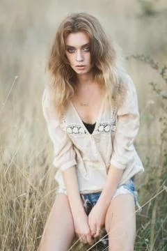 Young sexy model posing in a field at sunset Stock Photos