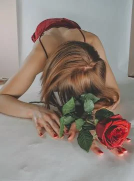 Young sexy woman in red lingerie with red rose Stock Photos