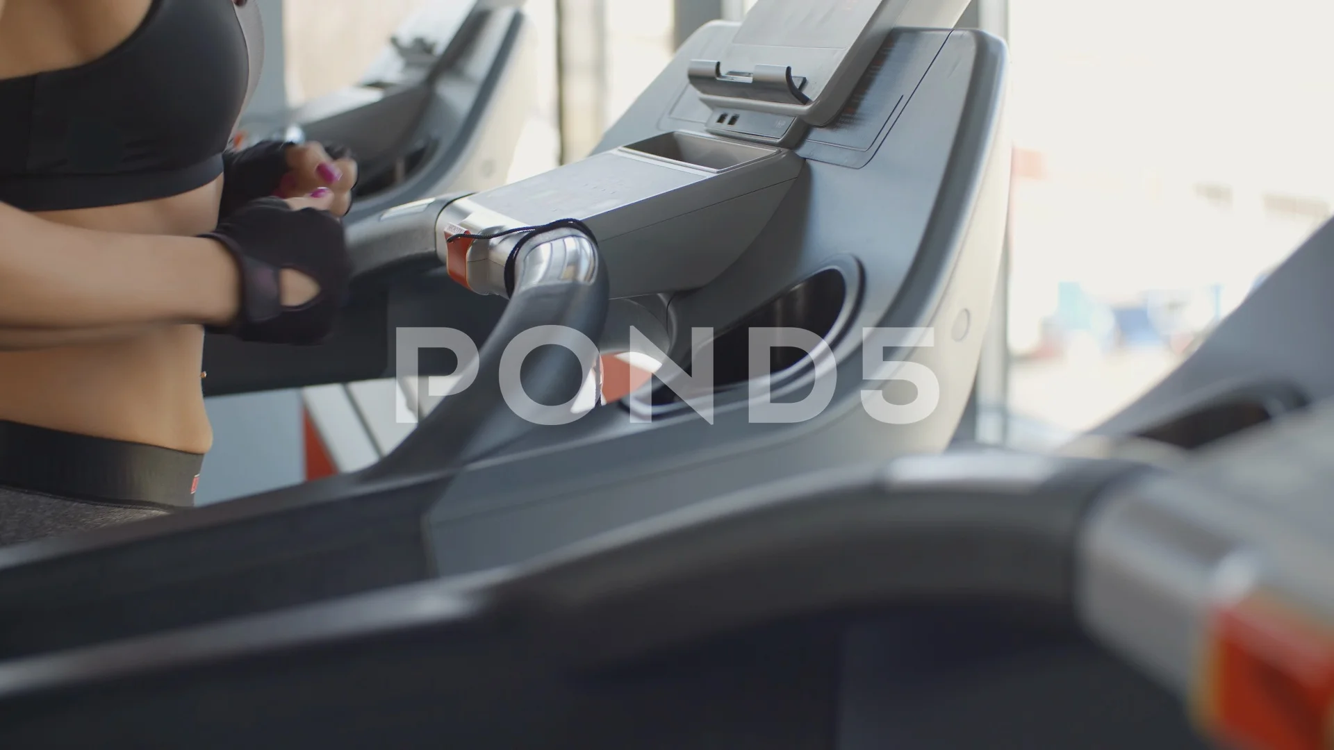 Young sexy woman running on a treadmill in the gym