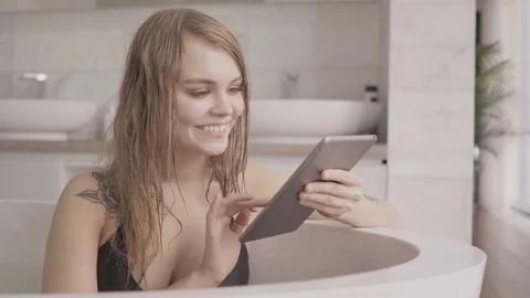 Young sexy woman using tablet computer in the bath Stock Footage 74243121