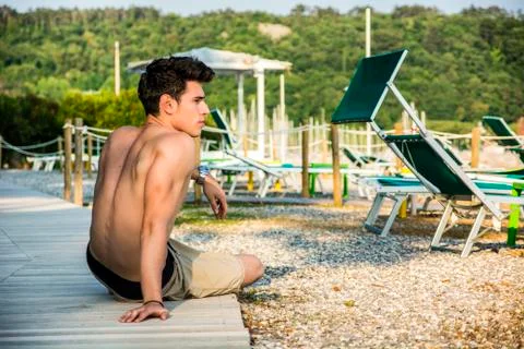 Young shirtless athletic man sitting at the beach Stock-Fotos