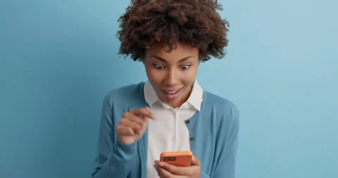 Young shocked curly haired young woman feels surpsied looks with disbelief at Stock Footage 143631085