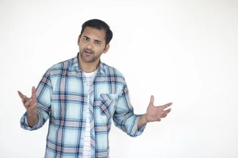 Young shocked man explaining and posing towards the camera - white background... Stock Photos