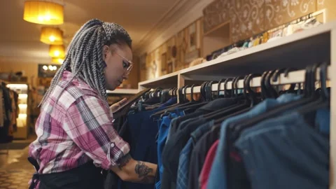 Young shop assistant of boutique using tablet searching for items on website Stock Footage 143570717