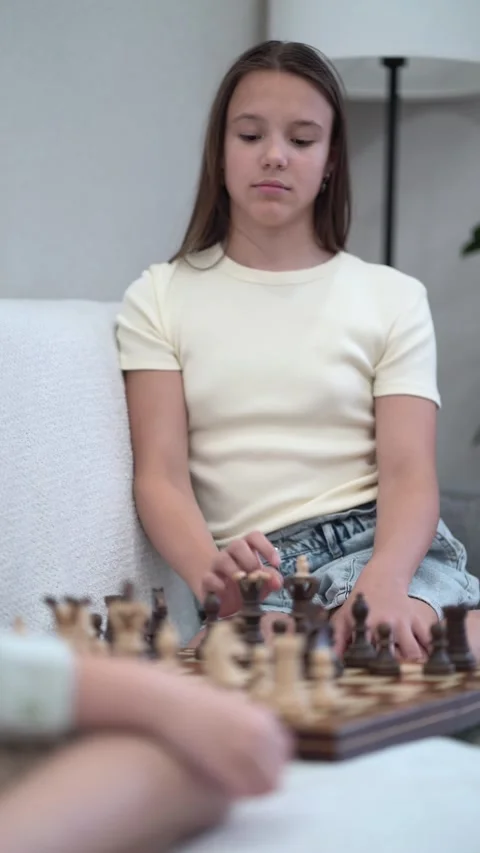 Young siblings enjoy a thoughtful game of chess indoors Video stock 342771772