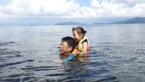 Young siblings playing in the sea Stock Footage 75251110