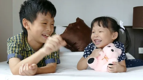 Young siblings playing toy on bed Stock Footage 79924808