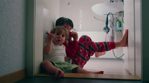 Young siblings sharing bedtime hygiene routine in bathroom while brushing t.. Stock Footage 337399289