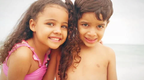 Young siblings smile on a beach Stock Footage 49577137