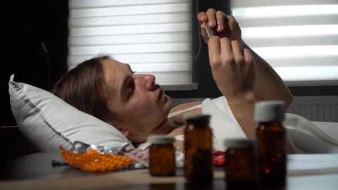 Young sick guy checks the temperature Stock Footage 125809803