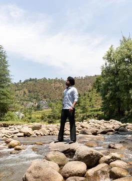 Young Sikh Man Posing on River Rocks With Large Copy Space in Himachal Pradesh Stock Photos