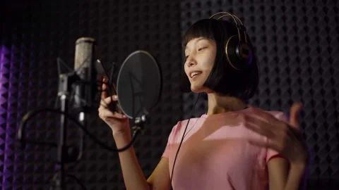Young singer reading lyrics on smartphone in studio Stock Footage 142403256