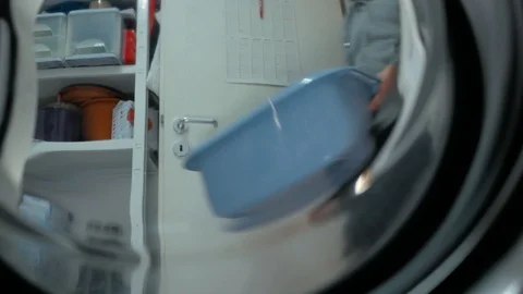 A young single man does the housework and wash some dirty laundry in the Stock Footage 97406246