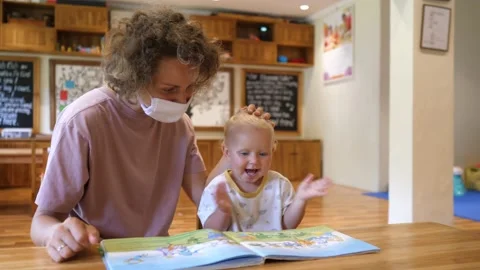 Young single mother educates her baby with fun reading. Toddler learning Stock Footage 148992012