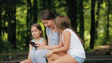 Young sisters at the park with tablet. Stock Footage 65743775