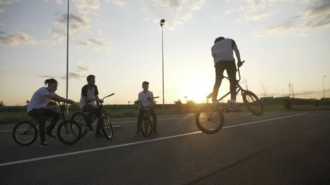 Young skilled biker practicing acrobatic technique of 360 rotation with his f Video stock 86369400