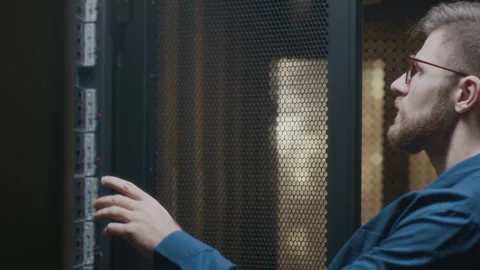Young Skilled Male IT Engineer Checking Mainframe in Server Room Video stock 303555717