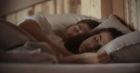 Young sleeping couple in bed Stock Footage