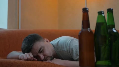 Young sleepy man waking up in bed after alcohol abuse and drug addiction Stock Footage 197079178