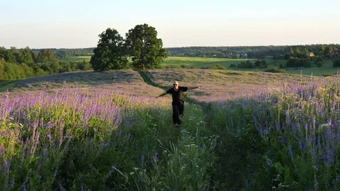 Young slender bald man in black casual clothes, sunglasses, runs along summer 库存影片 120122420