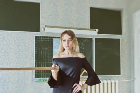 Young slender beautiful blonde teacher in a black dress Stock Photos