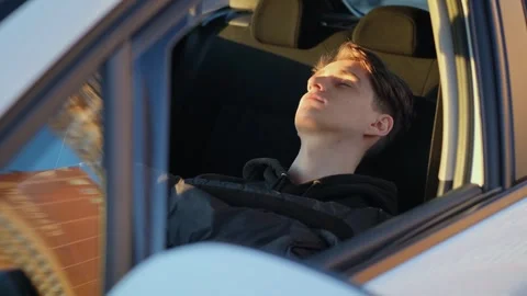 A young slender guy sleeps on a car seat Stock Footage 265703279