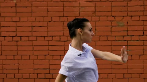 The young slim dark woman dancing against the red brick wall in the street. 4K 库存影片 120721753