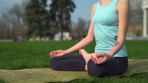Young slim female siting on mat in lotus pose and meditate close up slow motion Stock Footage