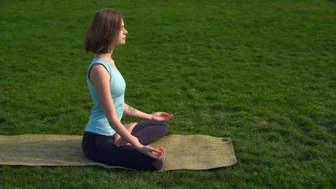 Young slim female siting on mat and make namaste after lotus pose slow motion Stock Footage