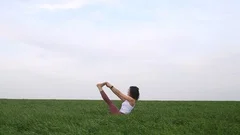 Young Slim Woman Sitting on the Yoga Mat and Puts Her Legs in