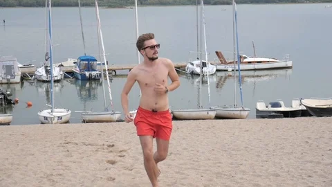 Young slim thin Man running on a Beach Stock Footage 94483872