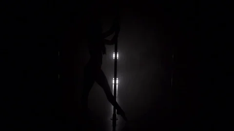 Young slim woman's silhouette dancing near the pole slow motion Video stock 74674704