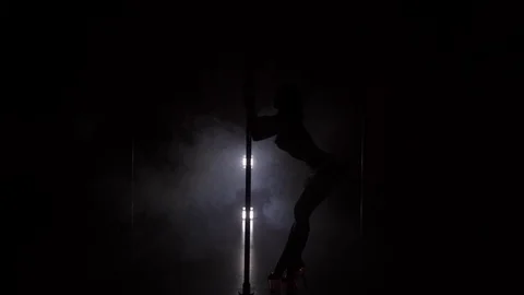 Young slim woman's silhouette dancing near the pole in the studio Stock Footage 74674960