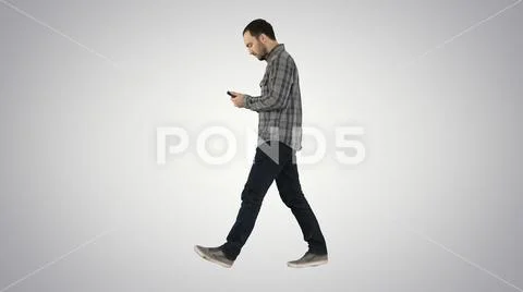 Young smart casual man walking and reading message on cell phone ~ Hi ...