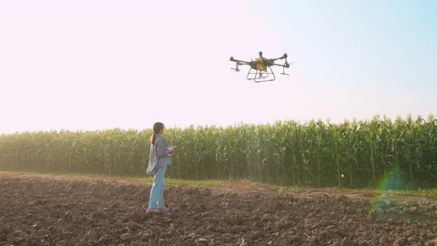 Young smart farmer controlling drone spraying fertilizer and pesticide over f Vídeo Stock 170569031