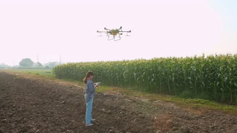 Young smart farmer controlling drone spraying fertilizer and pesticide over f 스톡 동영상 170569235