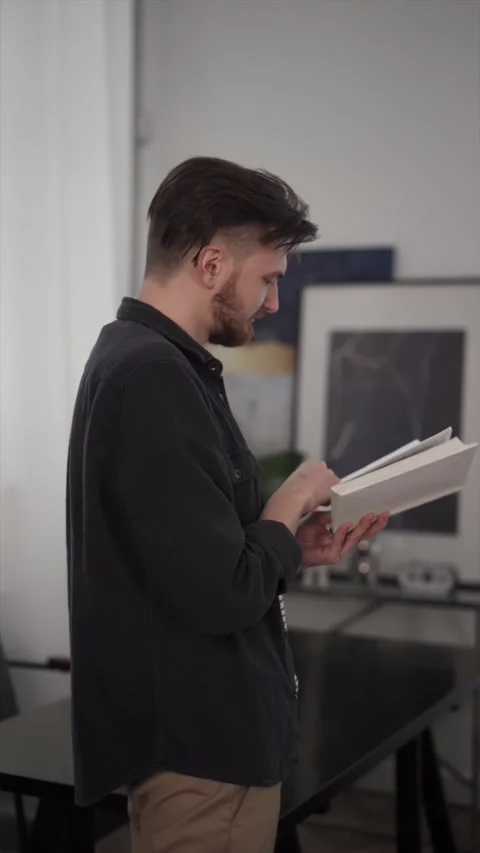 Young smart guy student man reading book at home Stock Footage 169048880