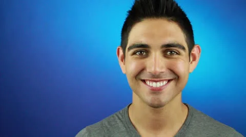 Young smart Hispanic Guy stands on a Blue background with a cute smile Stock Footage 22759856