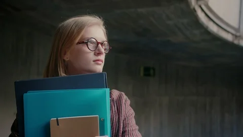Young smart nerd or geek girl in glasses looking to bright future of science Stock Footage 104717260