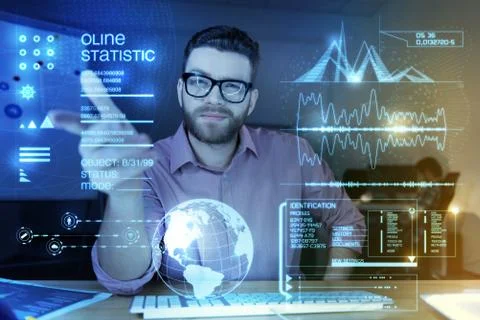 Young smart programmer pointing to the transparent screen and looking confident Stock-Fotos