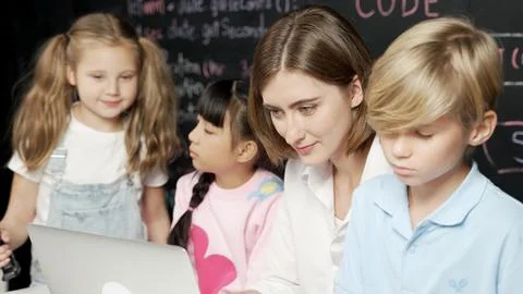 Young smart teacher using laptop to teach student programing system. Erudition. Fotos de archivo