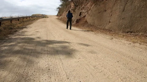 Young smartly dressed African walking along dirt road Stock Footage 48336185