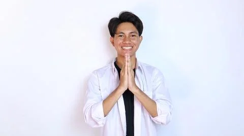 Young smiling Asian man gesturing welcome 写真素材