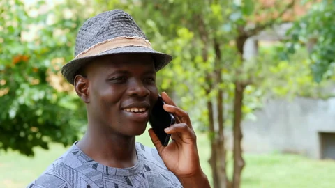 Young smiling black man talking on the cellphone - outdoor Stock Footage 136543532