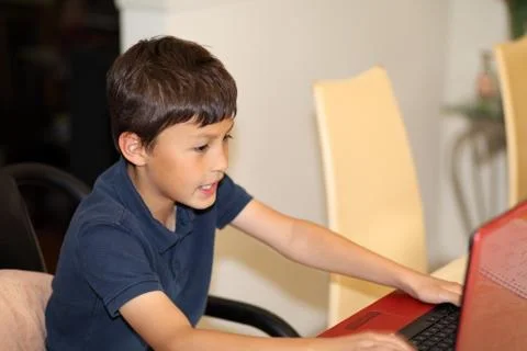 Young smiling boy typing on a computer Stock Photos