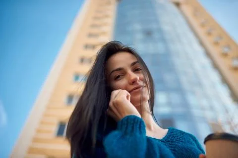 Young smiling brunette using her smartphone outdoors Foto stock