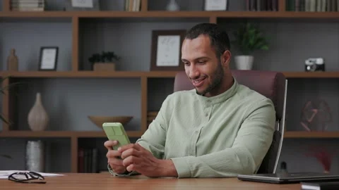 Young smiling businessman using smartphone and smiling. Texting message, surfing Stock Footage 201973837